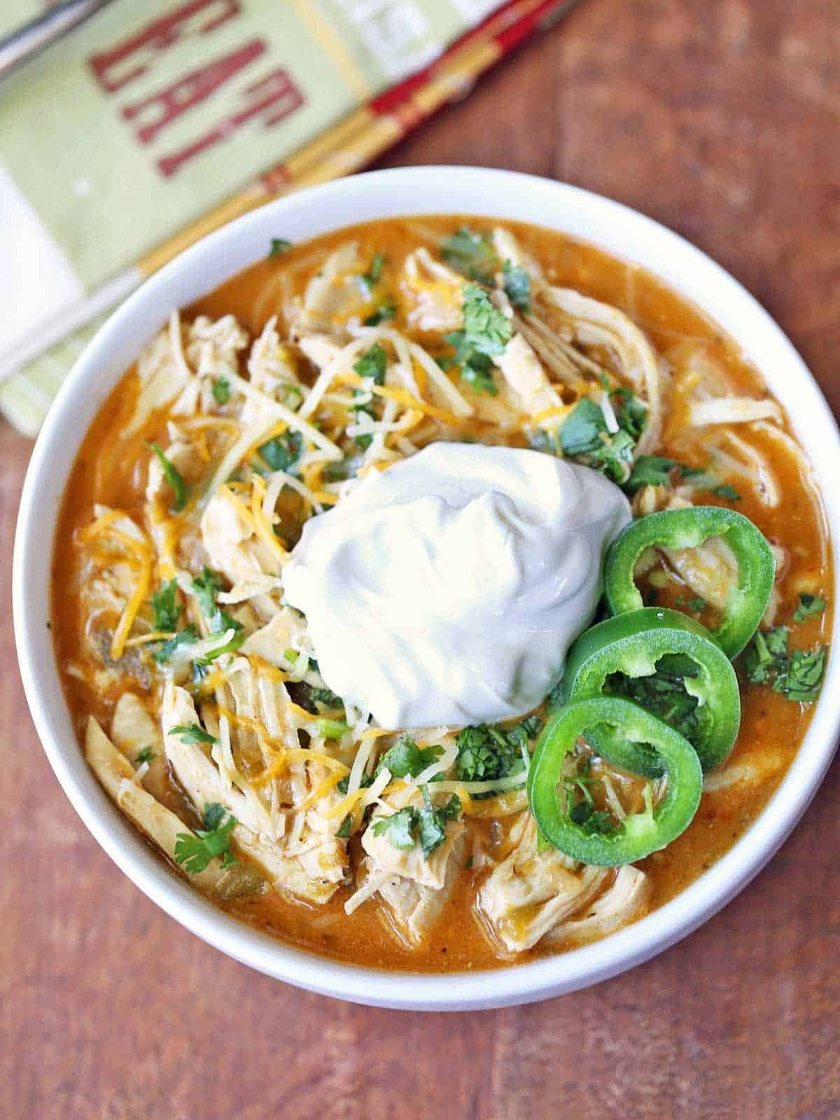 Top view of a bowl of leftover chicken chili with cream on top. 