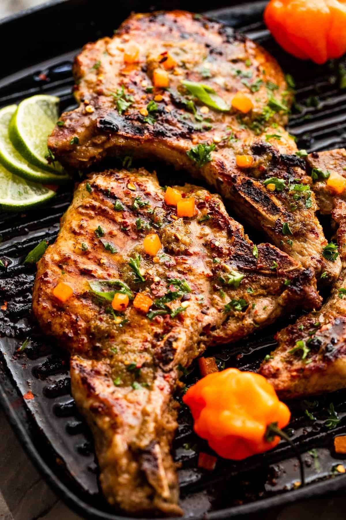 Pork chops seasoned with herbs and spiced grilled on a pan. 