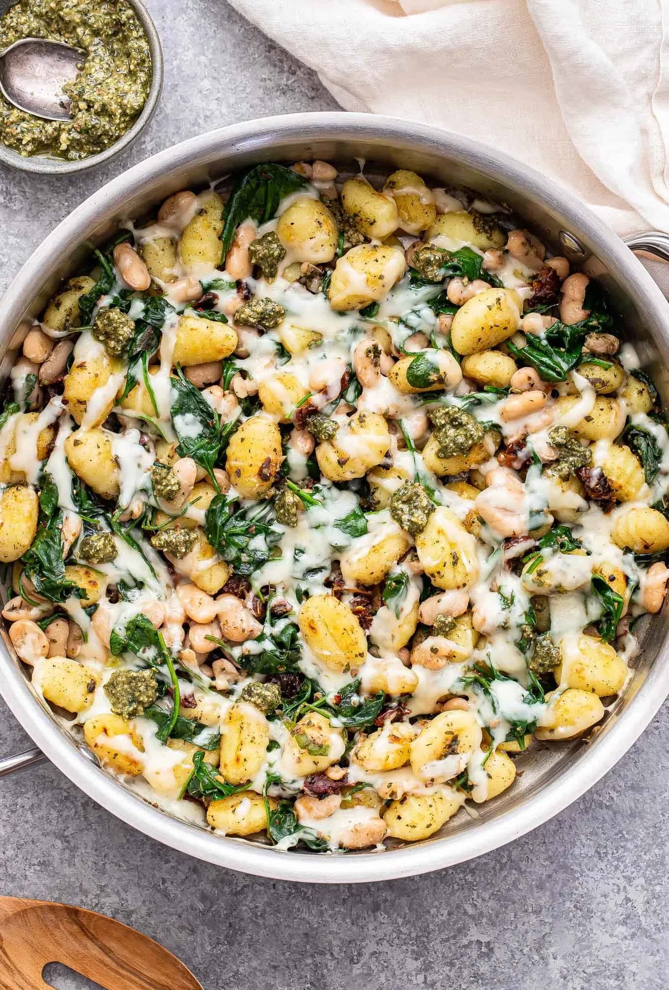 Spinach white bean gnocchi cooked in a skillet. 