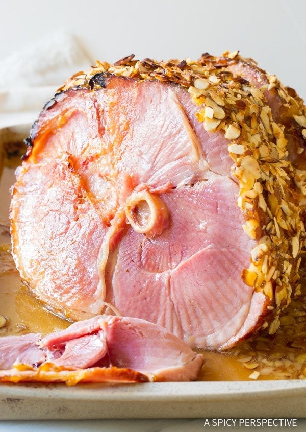 Sliced almond crusted baked ham with apricot glaze.