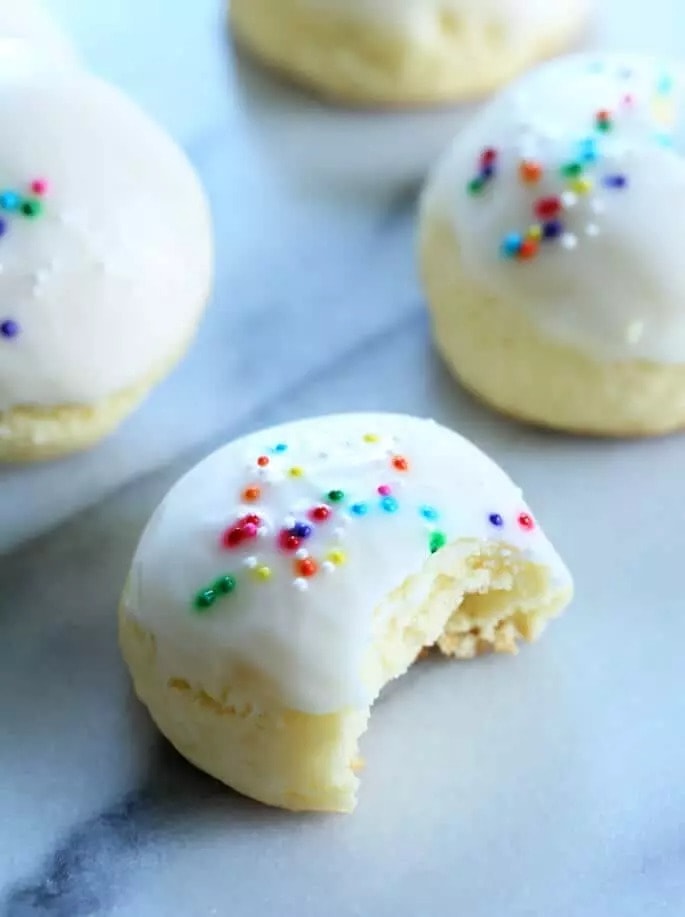 Anisette cookies with cream frosting and sprinkles on top. 