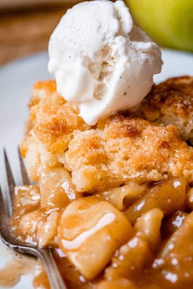 A serving of apple cobbler topped with a scoop of vanilla ice cream. 