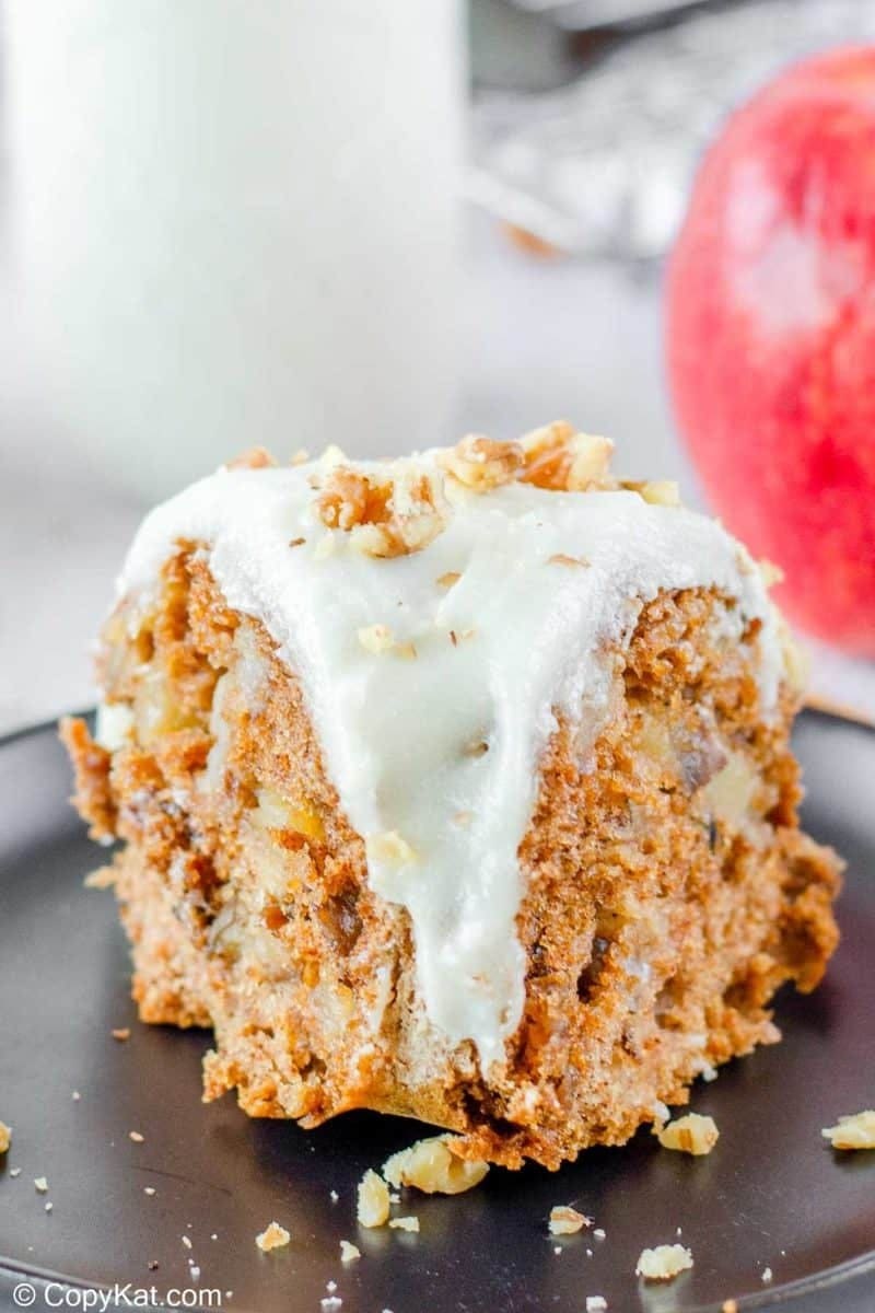 A piece of slice of apple spice cake topped with whipped cream.