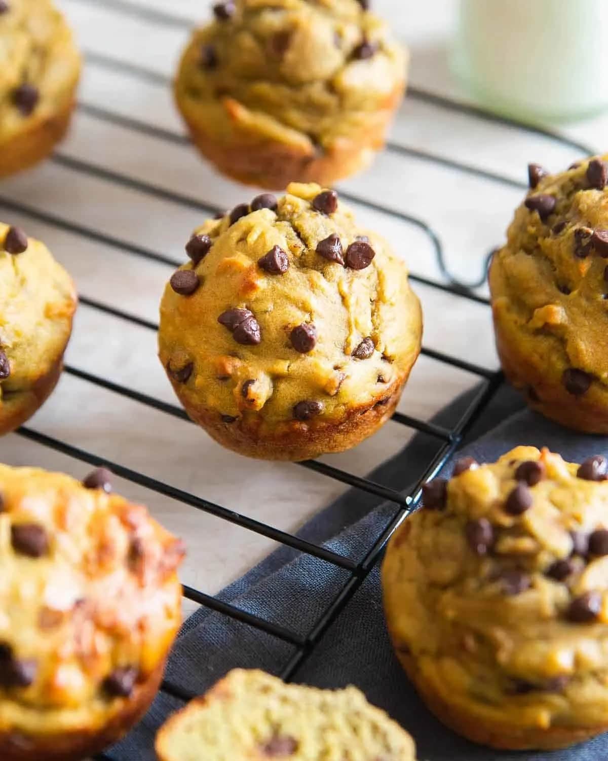 Avocado muffins with chocolate chips on cooling rack.
