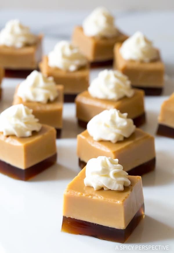 Layered Jello shots cut in cubes topped with a dollop of whipped cream. 