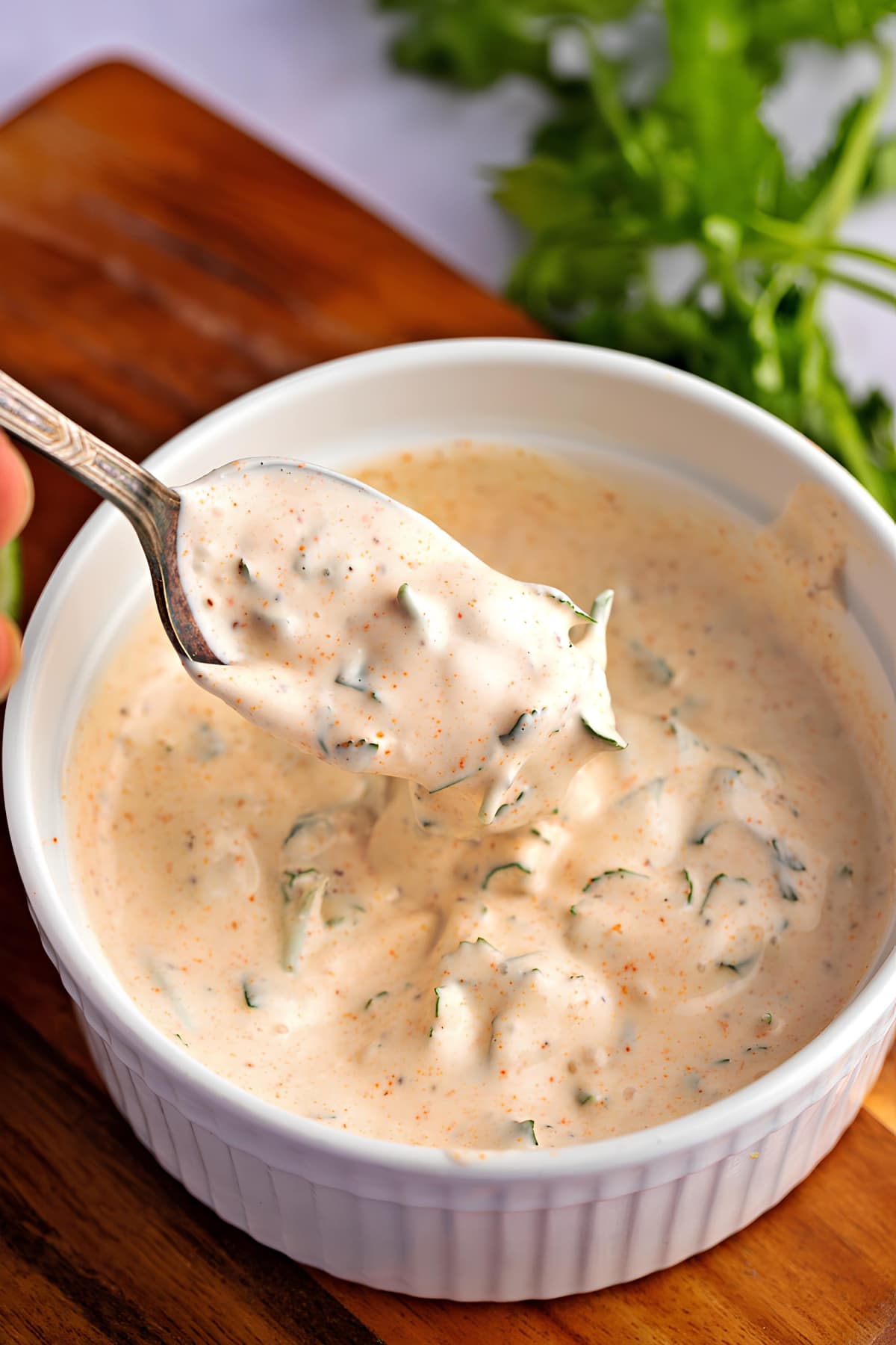Creamy Baja sauce scooped with a spoon in a small dish bowl.