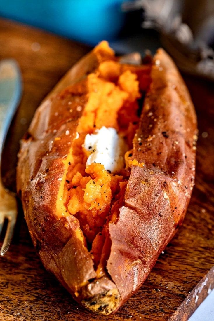 Baked sweet potato cut in half with butter inside. 