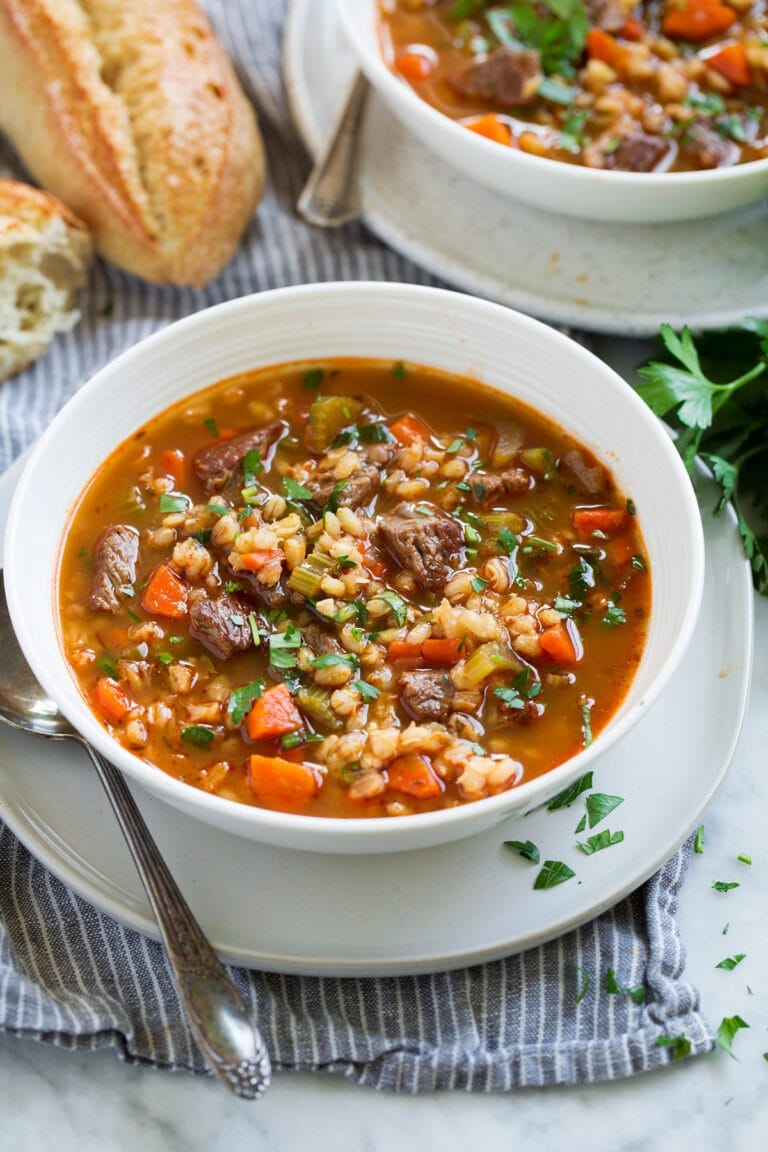 Bowls of Beef Barley Soup with mushrooms, green beans, canned tomatoes, potatoes or peas and carrots