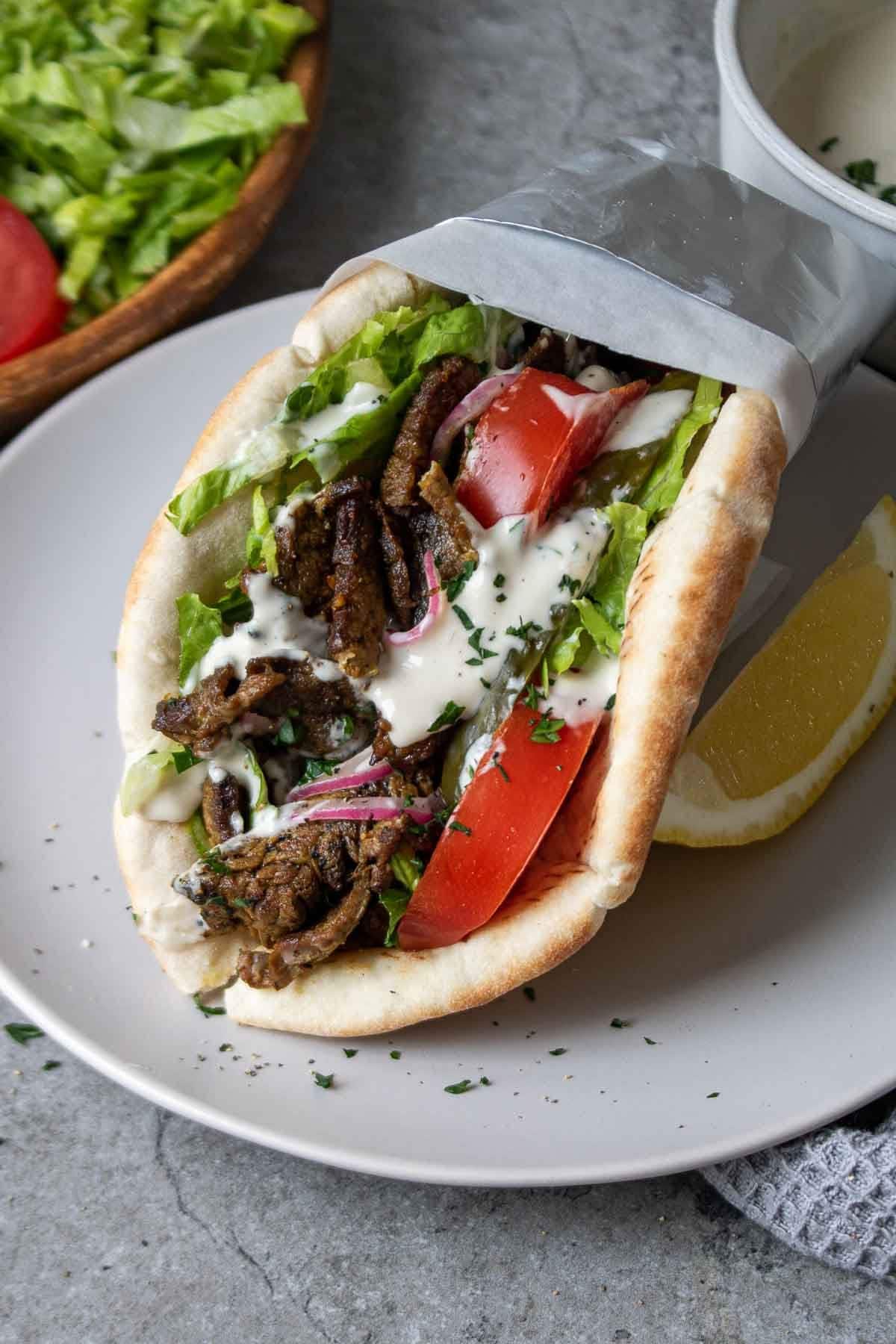 Delicious beef shawarma wrap wit tomatoes, herbs and creamy sauce