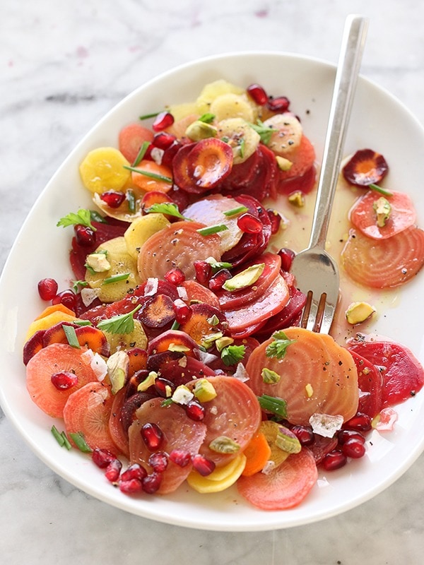 Salad made of  slices of beets and carrots with a sprinkle of pomegranate seeds and pistachios. 
