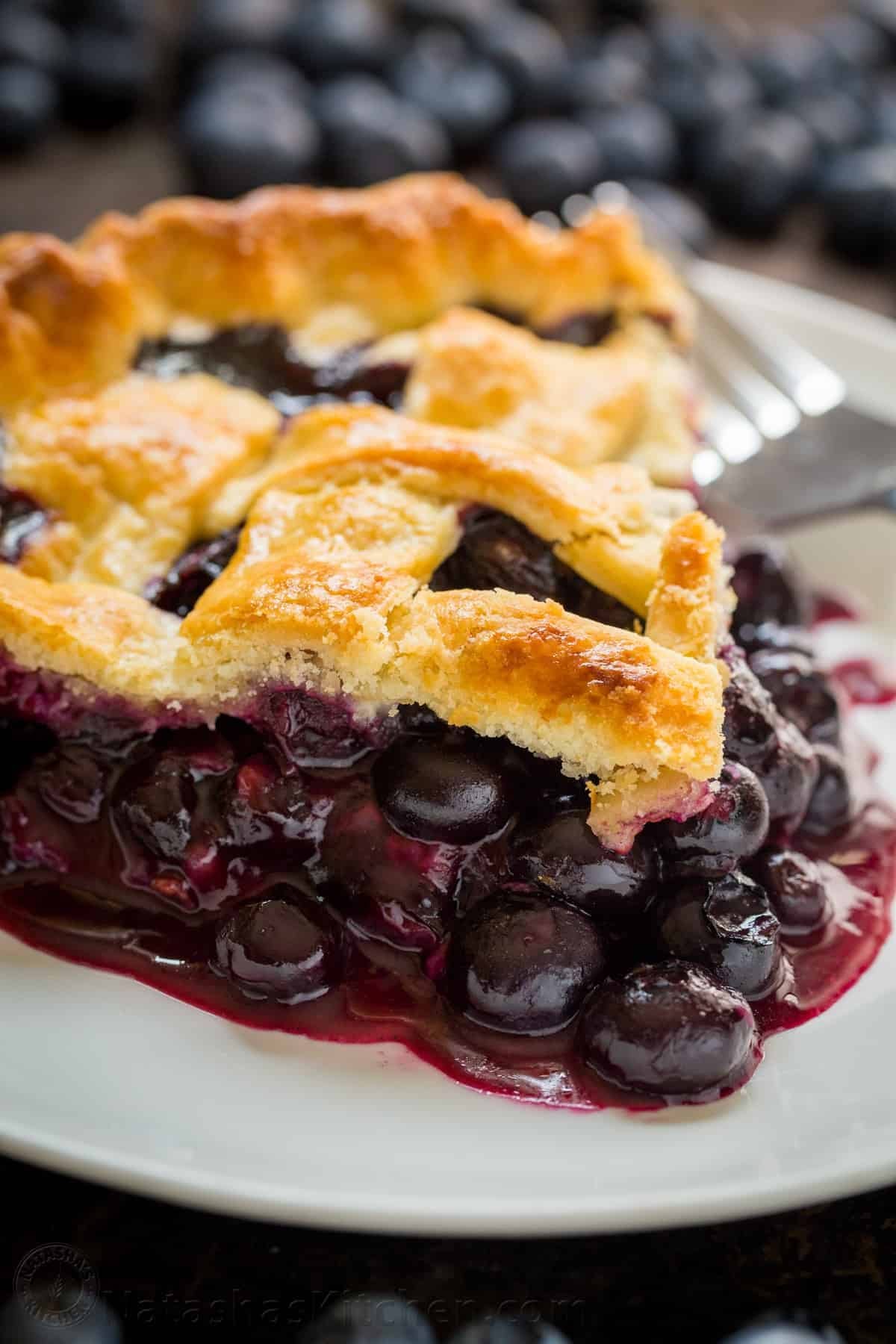 A serving of blueberry pie slice of a plate.