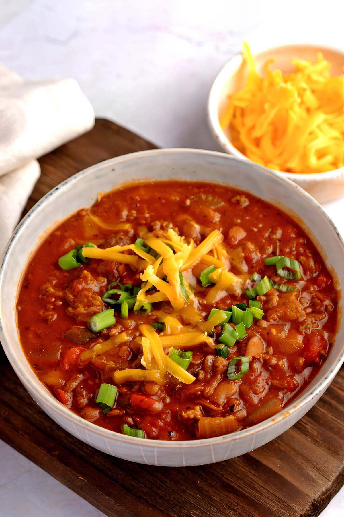 Boilmaker chili with ground beef and sausage topped with cheese and green onions