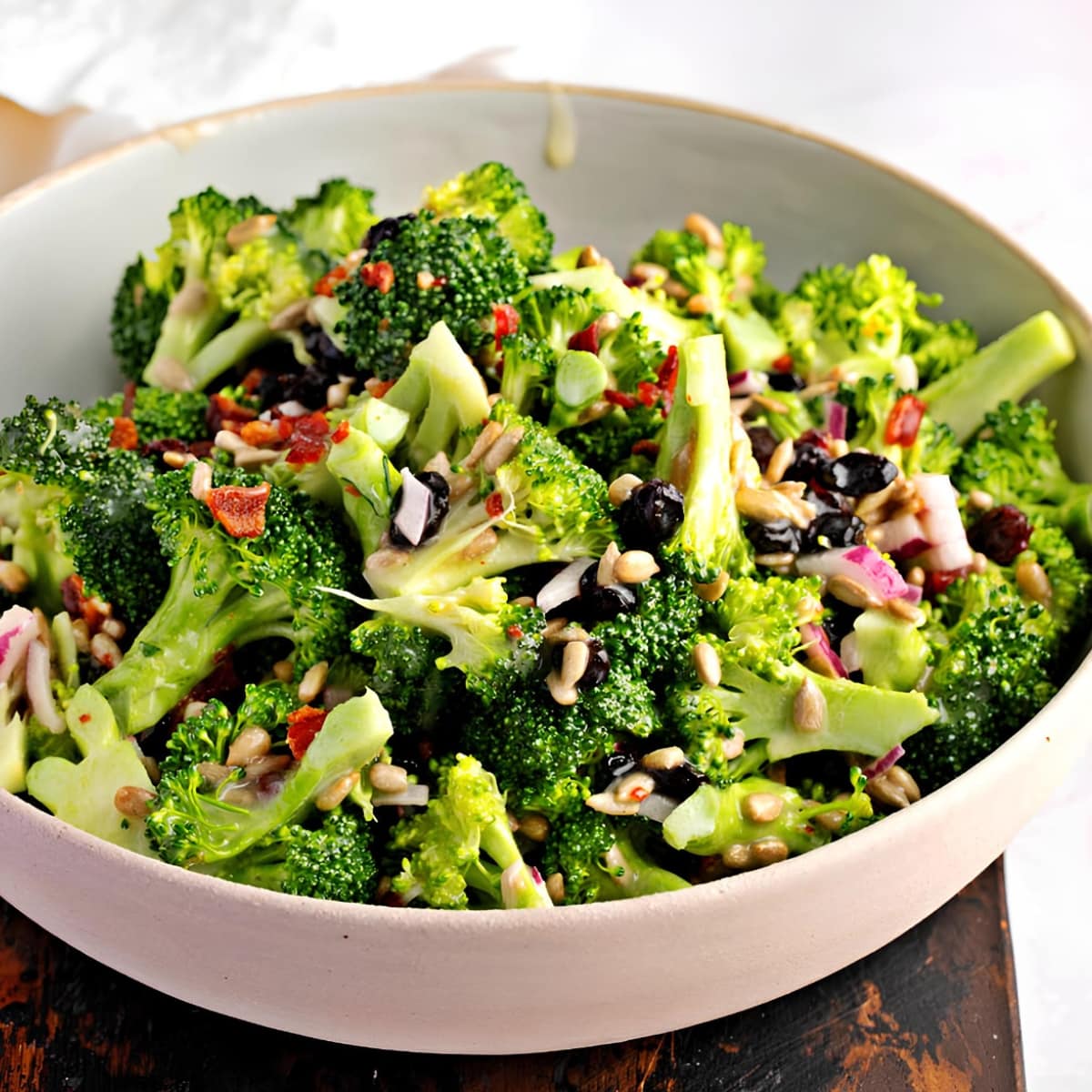 A Bowl of Broccoli Salad with Bacon, Raisins, Sunflower Seeds, and Creamy Dressing