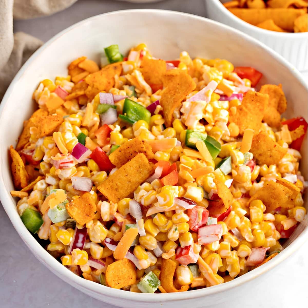 A bowl of corn salad with chips and corn, a refreshing and crunchy dish perfect for a light meal or snack