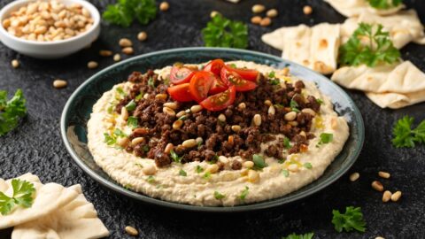 Homemade Hummus with Ground Beef in a Bowl Topped with Tomatoes