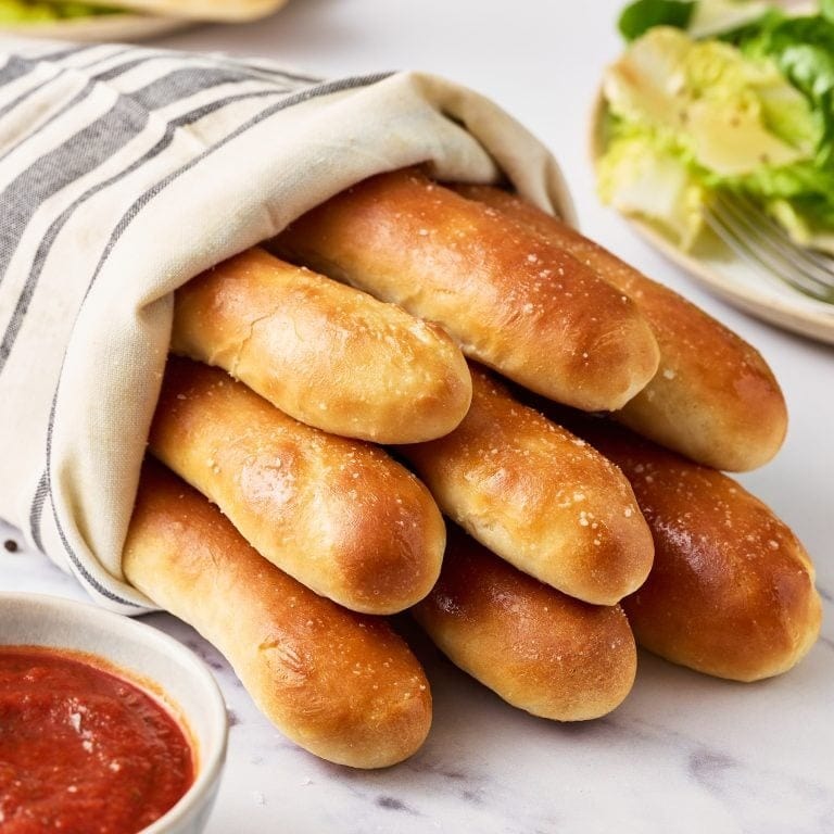 Bunch of breadsticks wrapped in cloth.
