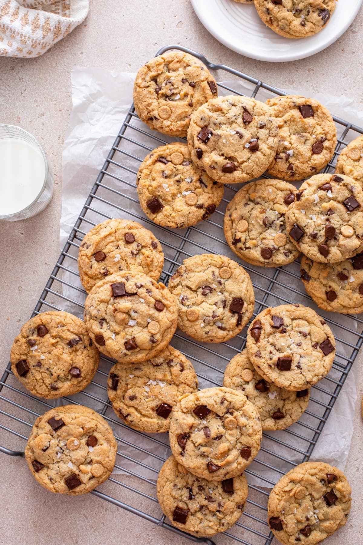 Best Brown Butter Chocolate Chip Cookies featuring A cooling rack with freshly baked cookies and a glass of milk