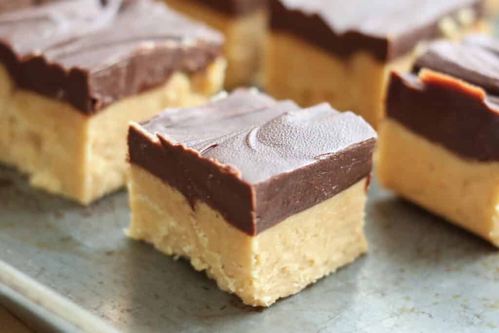 Sliced fudge with layer of chocolate and peanut butter  on a sheet pan.