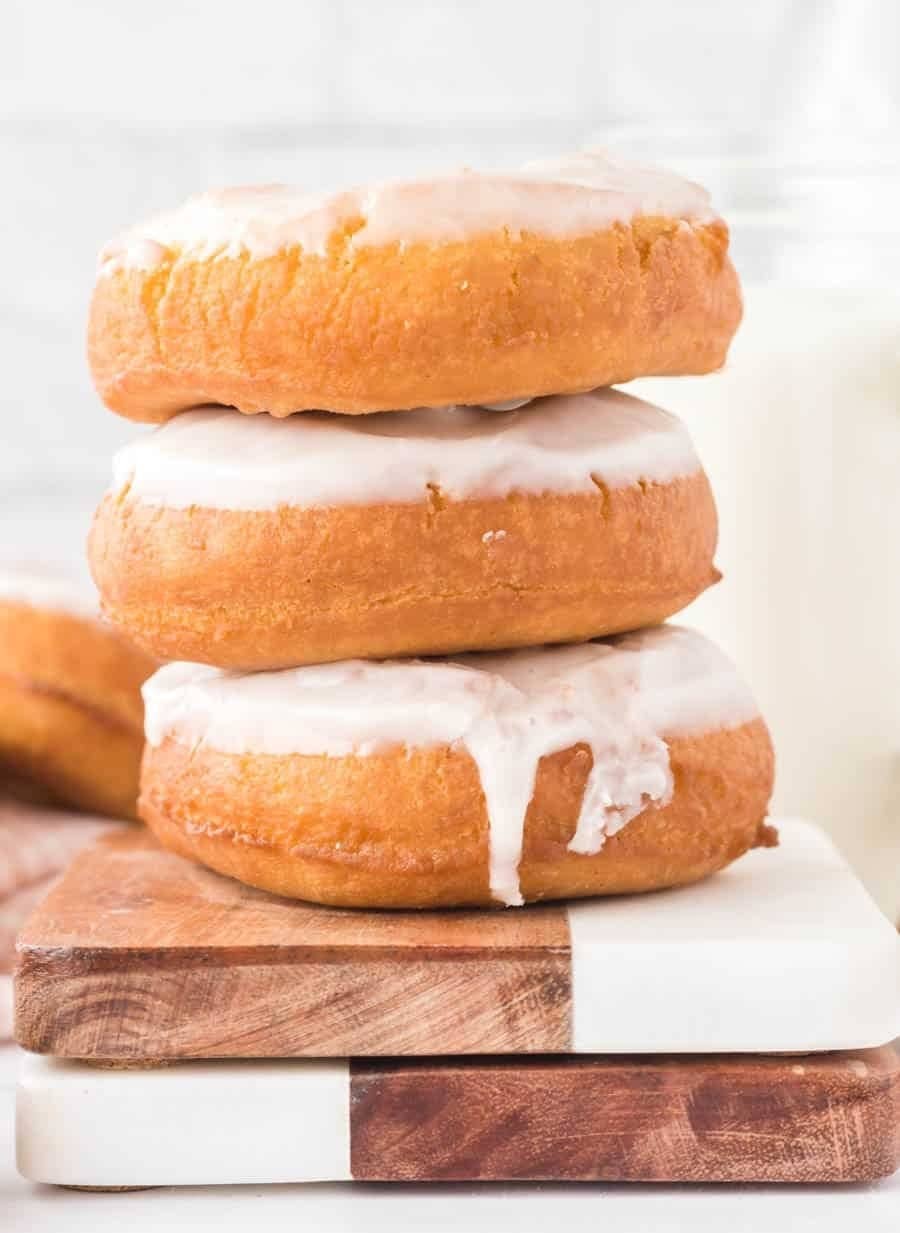 Stack of donuts with glazed buttermilk on top on a wooden board