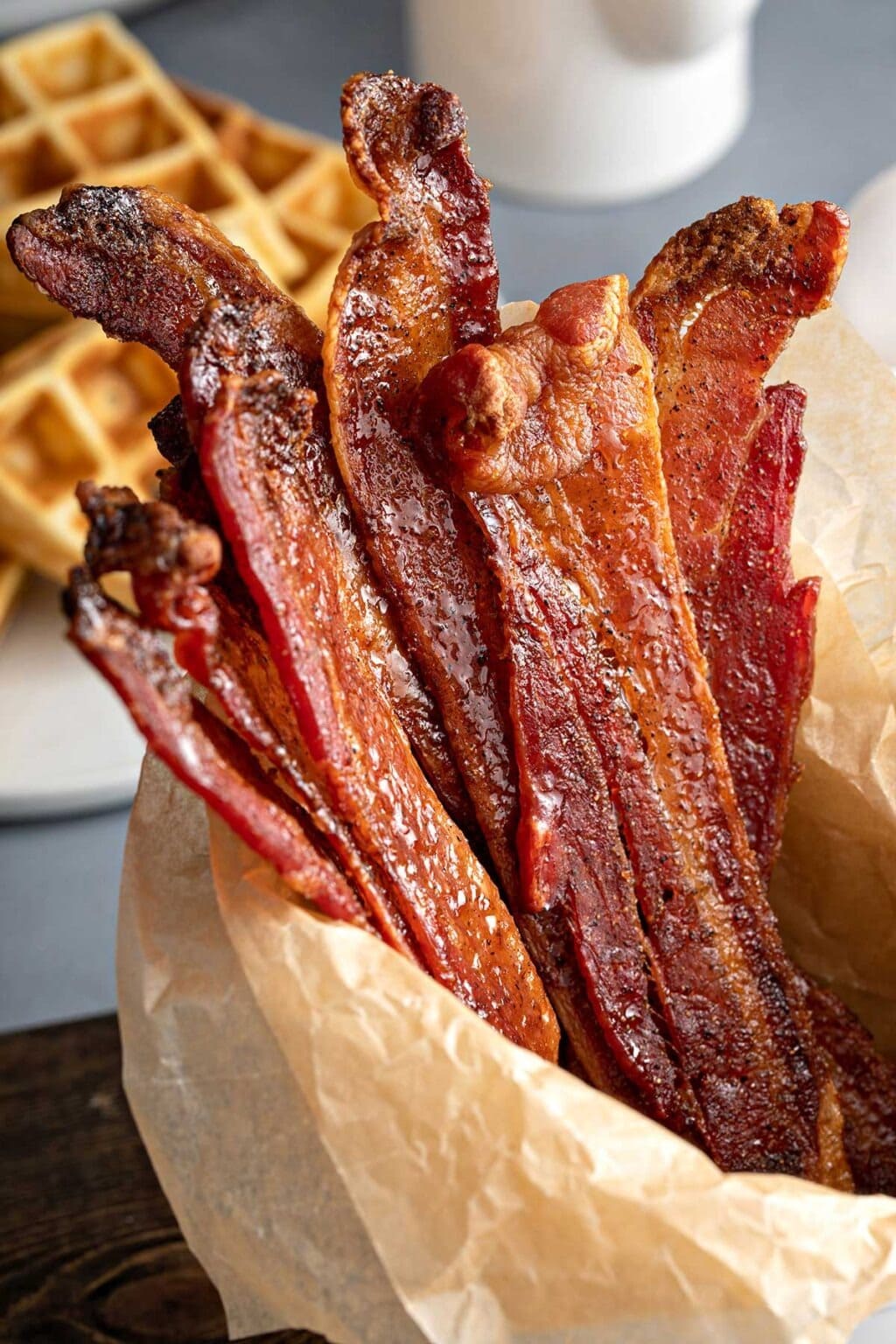 Candied bacon strips wrapped in parchment paper. 