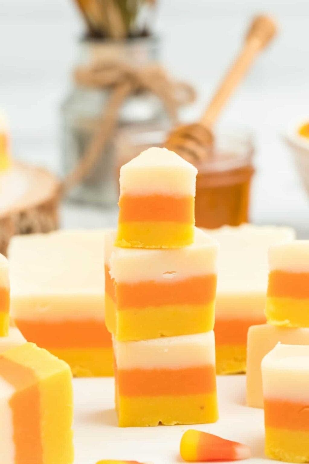 Bunch of yellow, orange, and white stripes fudge scattered on the table surface. 