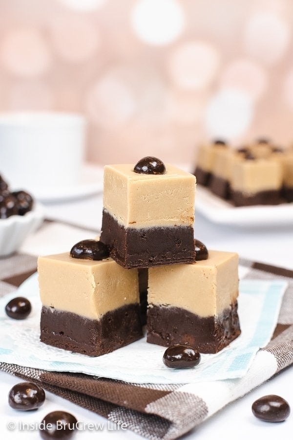 Stack of homemade fudge with layers of cappuccino and chocolate with chocolate covered coffee beans garnish.