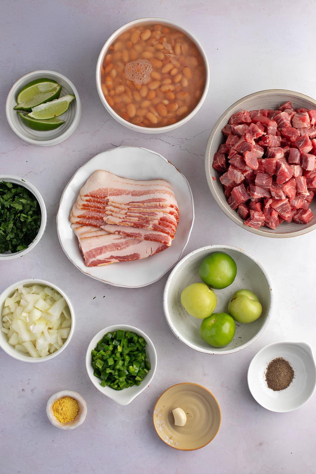 Ingredients for Carne En Su Jugo: Bacon, Tomatillos, Peppers, Garlic, Flank Steak, Chicken Bouillon, Beans and Garnishes