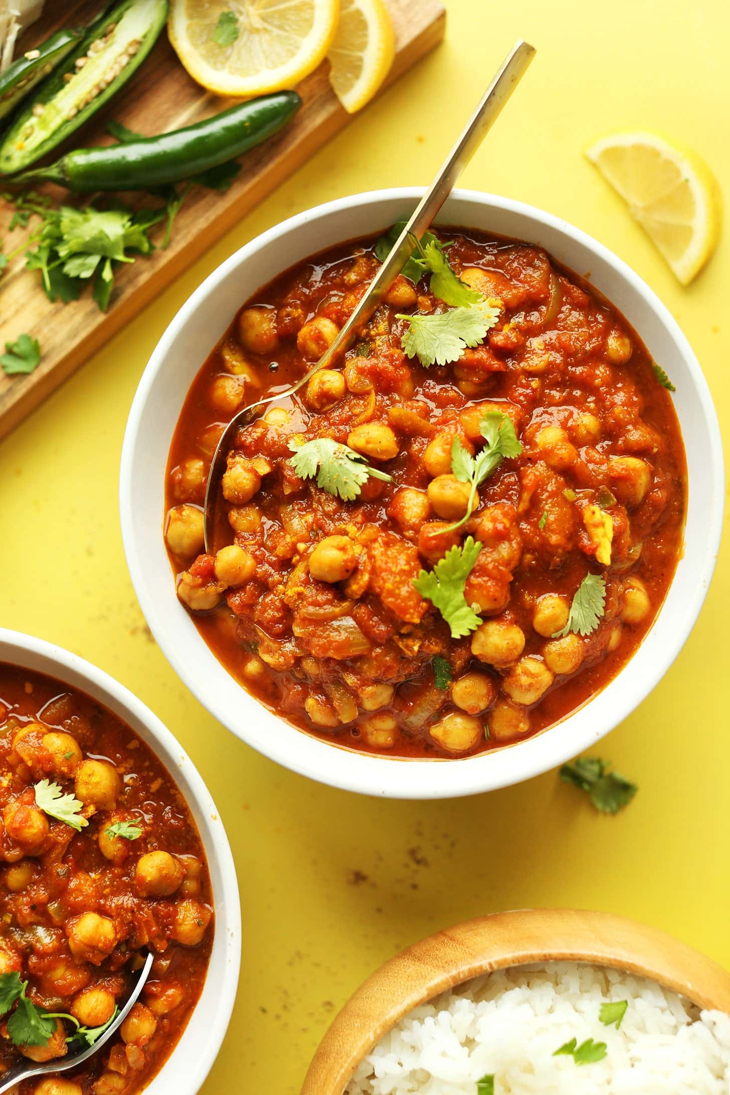 Bowls of Chana Masala with peppers, lemon slices and parsley