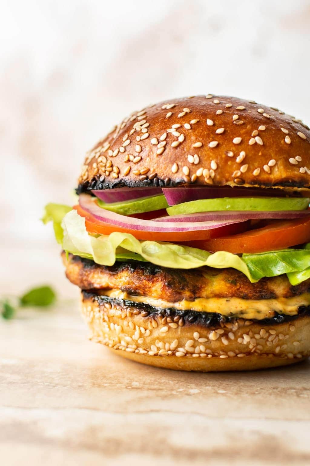 Chicken burger made with patty, slices of tomato, cucumber and lettuce. 