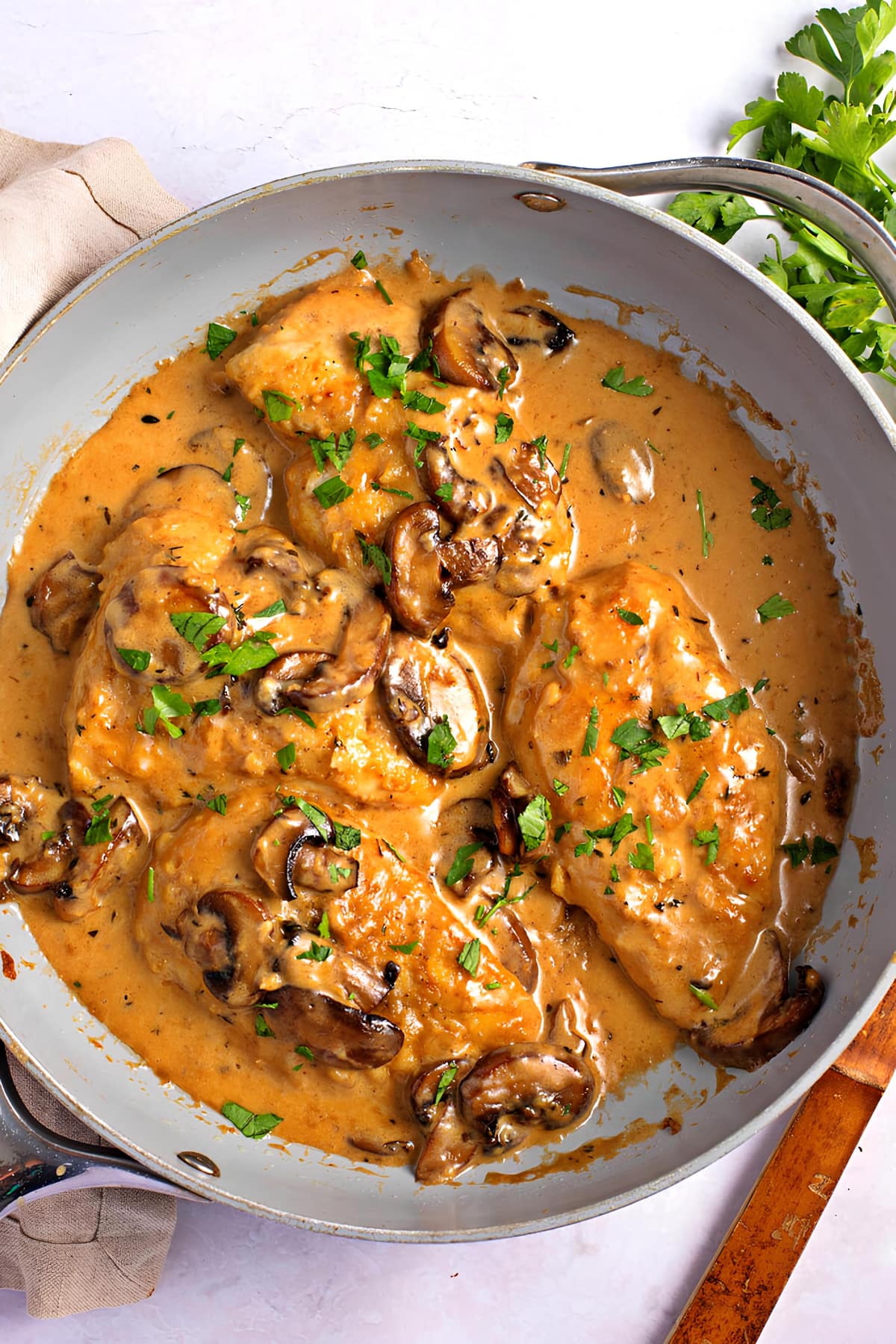 Top view of chicken marsala cooked in a pan garnished with chopped parsley.