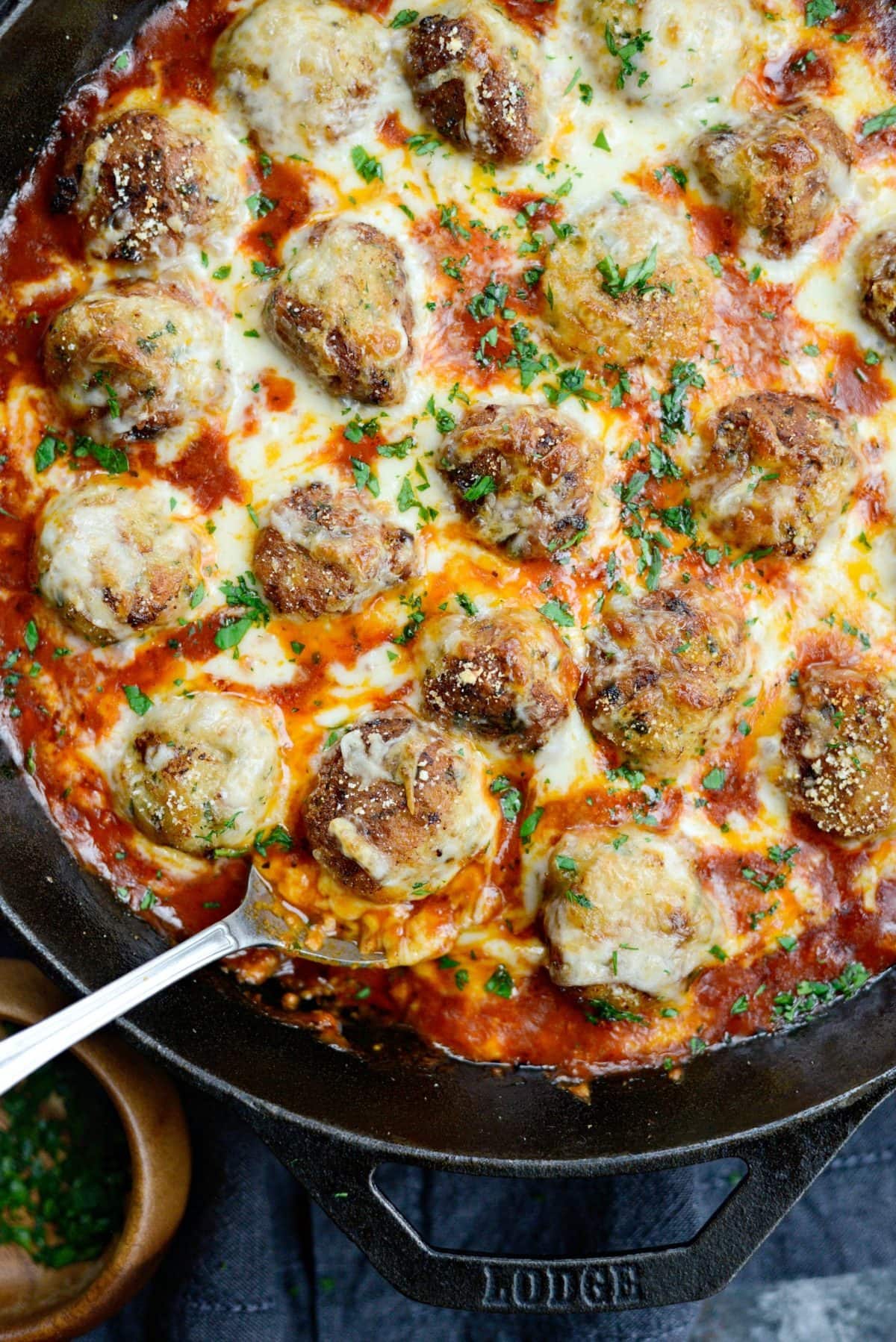 Chicken meatball with parmesan and sauce in skillet. 