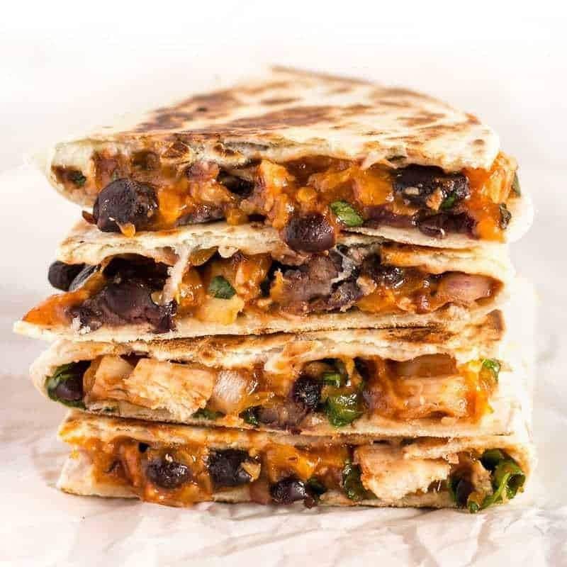 Stacks of Chicken and Pineapple Quesadillas on a parchment paper