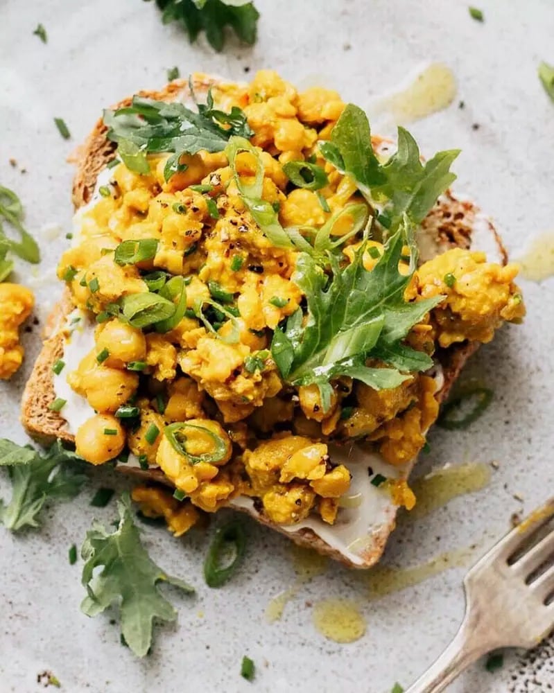 Chickpea Scramble on Toast garnished with spring onions and arugula