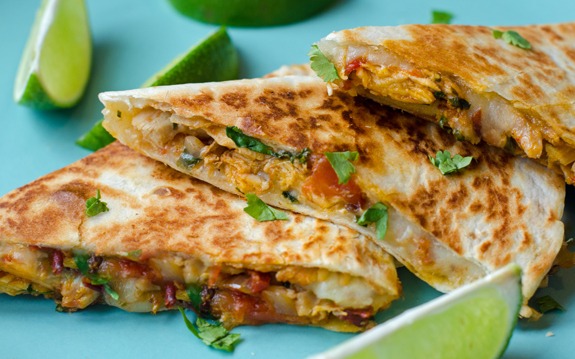 Sliced quesadillas with melted cheddar cheese, chipotle peppers, adobo sauce, and spices fillings,