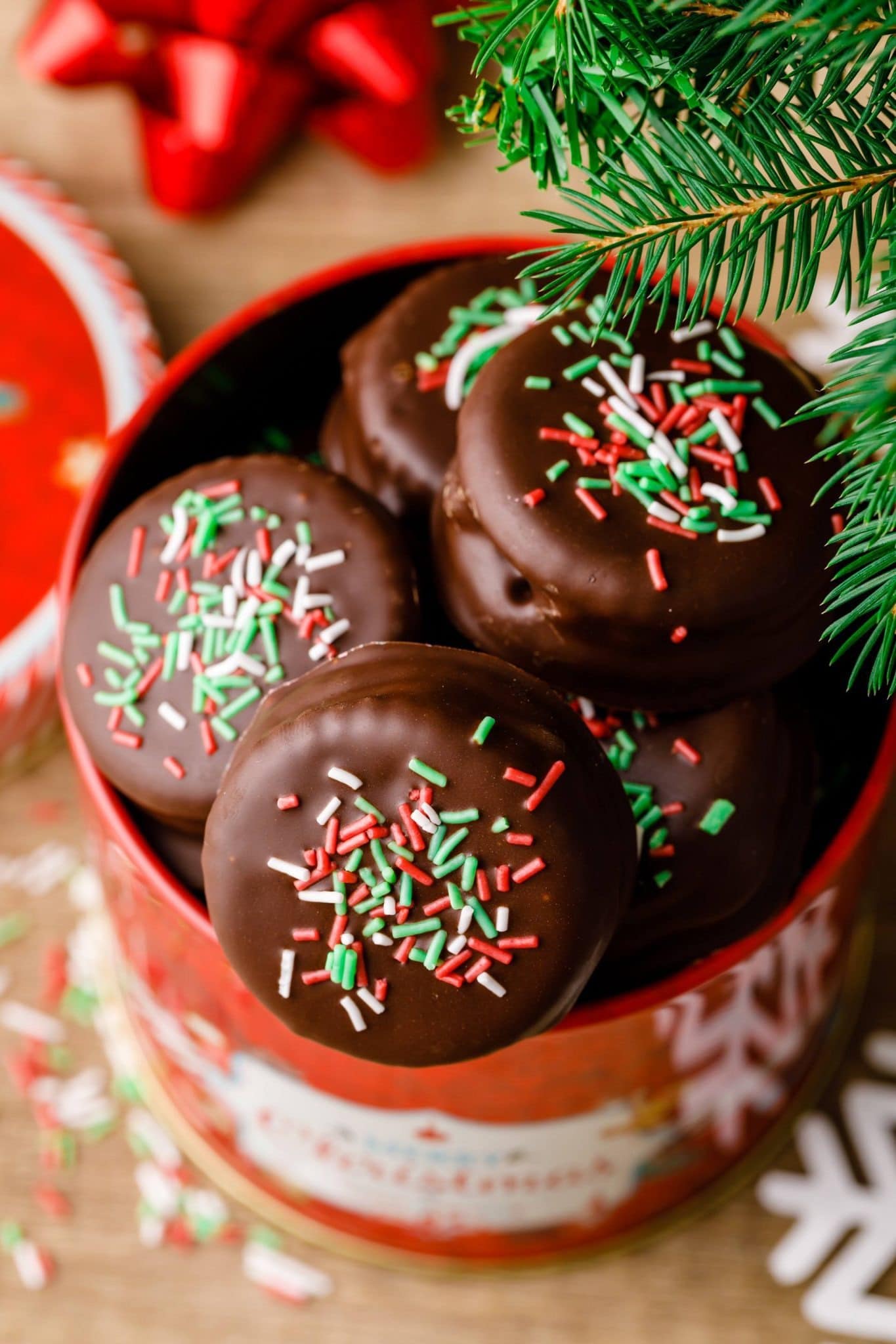 Chocolate coated crackers with sprinkles on top placed on a holiday can.