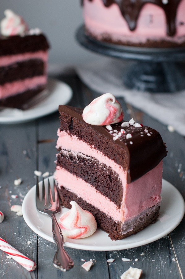 Slice of Layered dark chocolate mint cake frosted with a pink peppermint cream cheese buttercream.