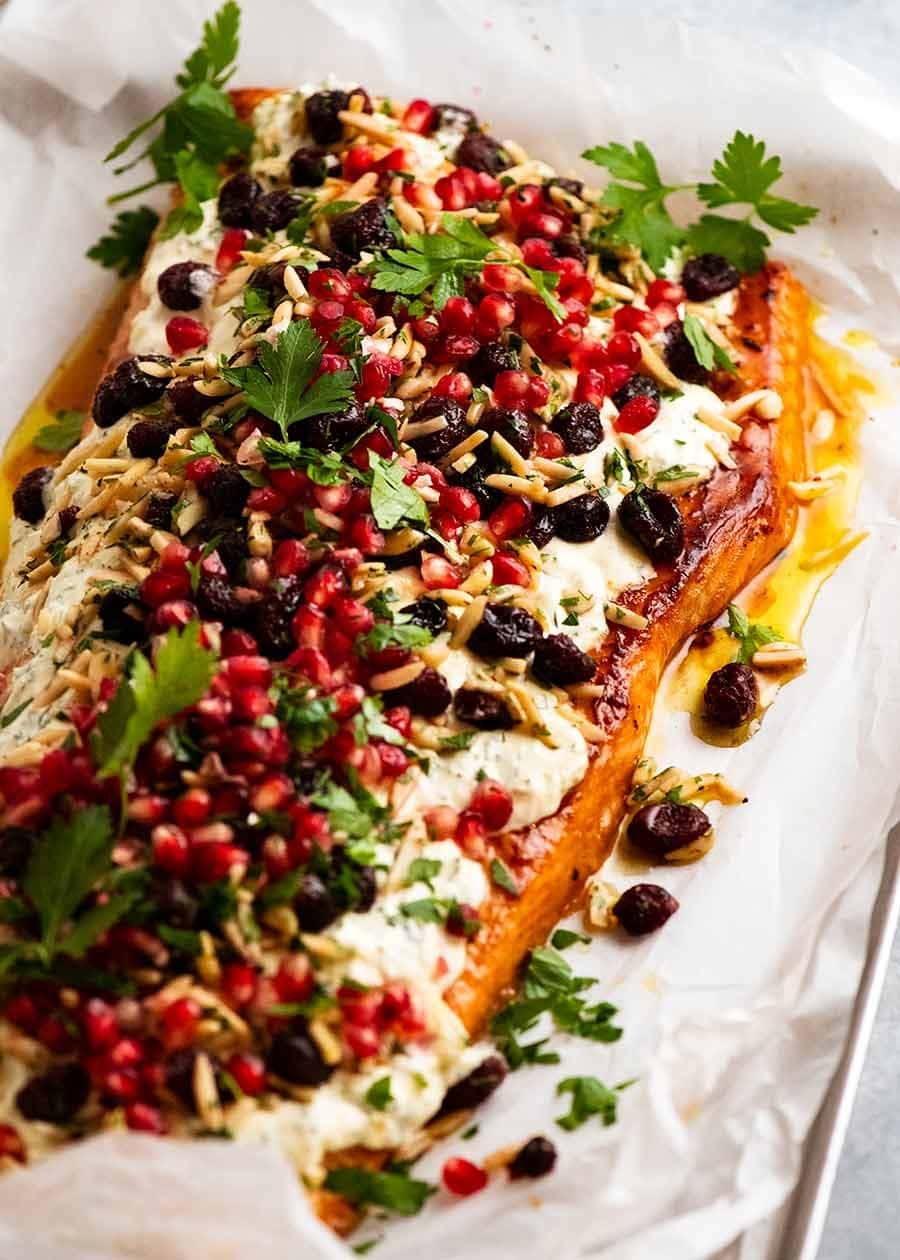 Baked salmon topped with white sauce,  cranberries, almonds, parsley, lemon juice and pomegranate seeds