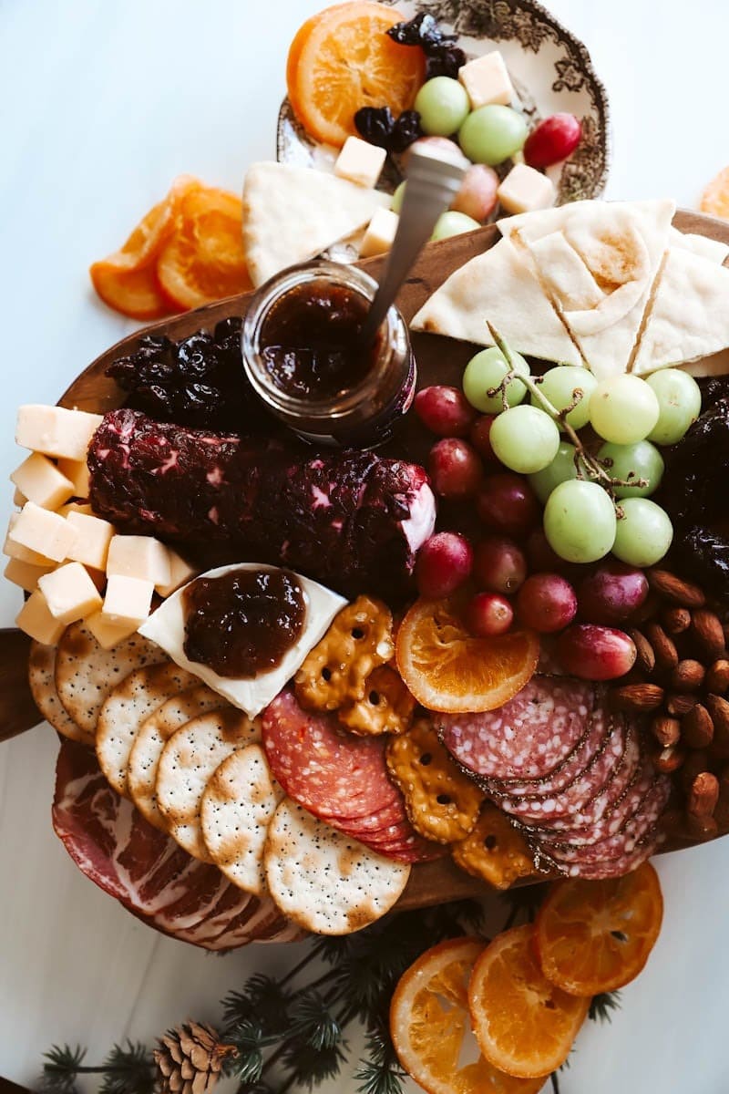 Charcuterie board with crackers, fruits, nuts, jams, meats, and cheese. 