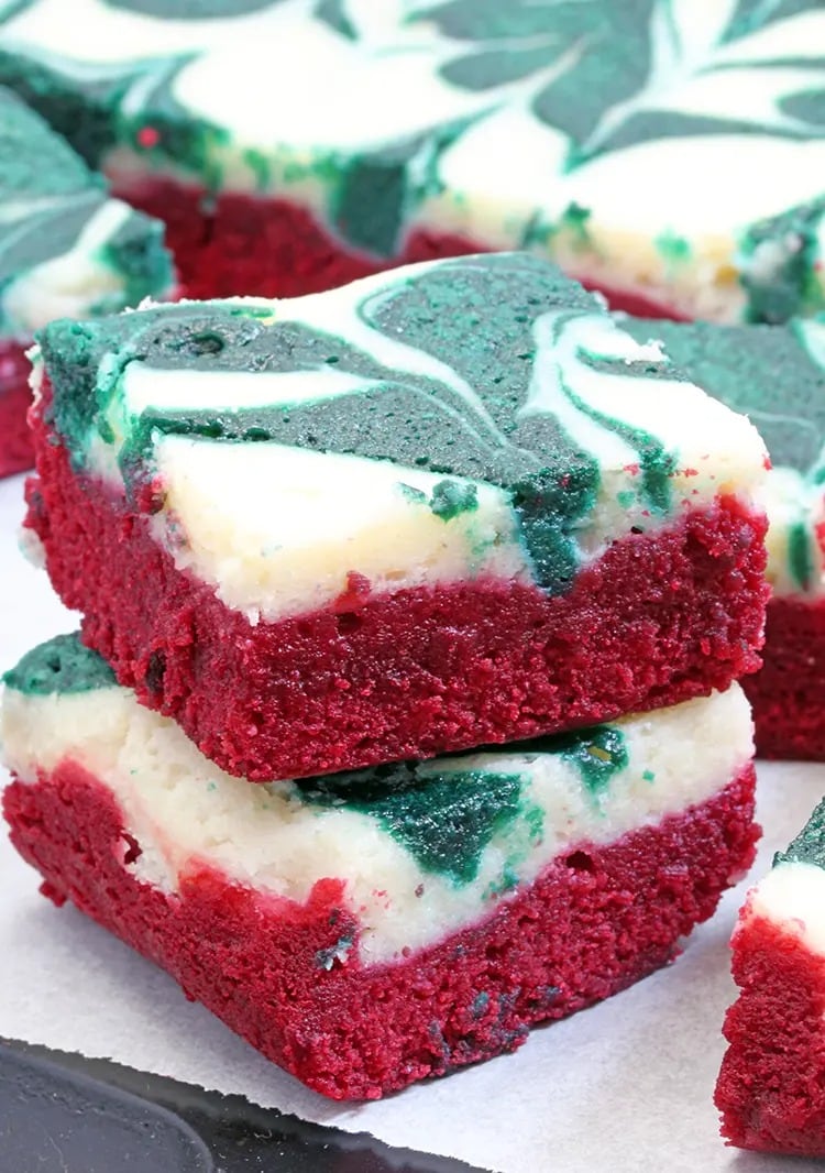 Bars of red velvet brownies with swirl of vanilla and green cheesecake on top. 