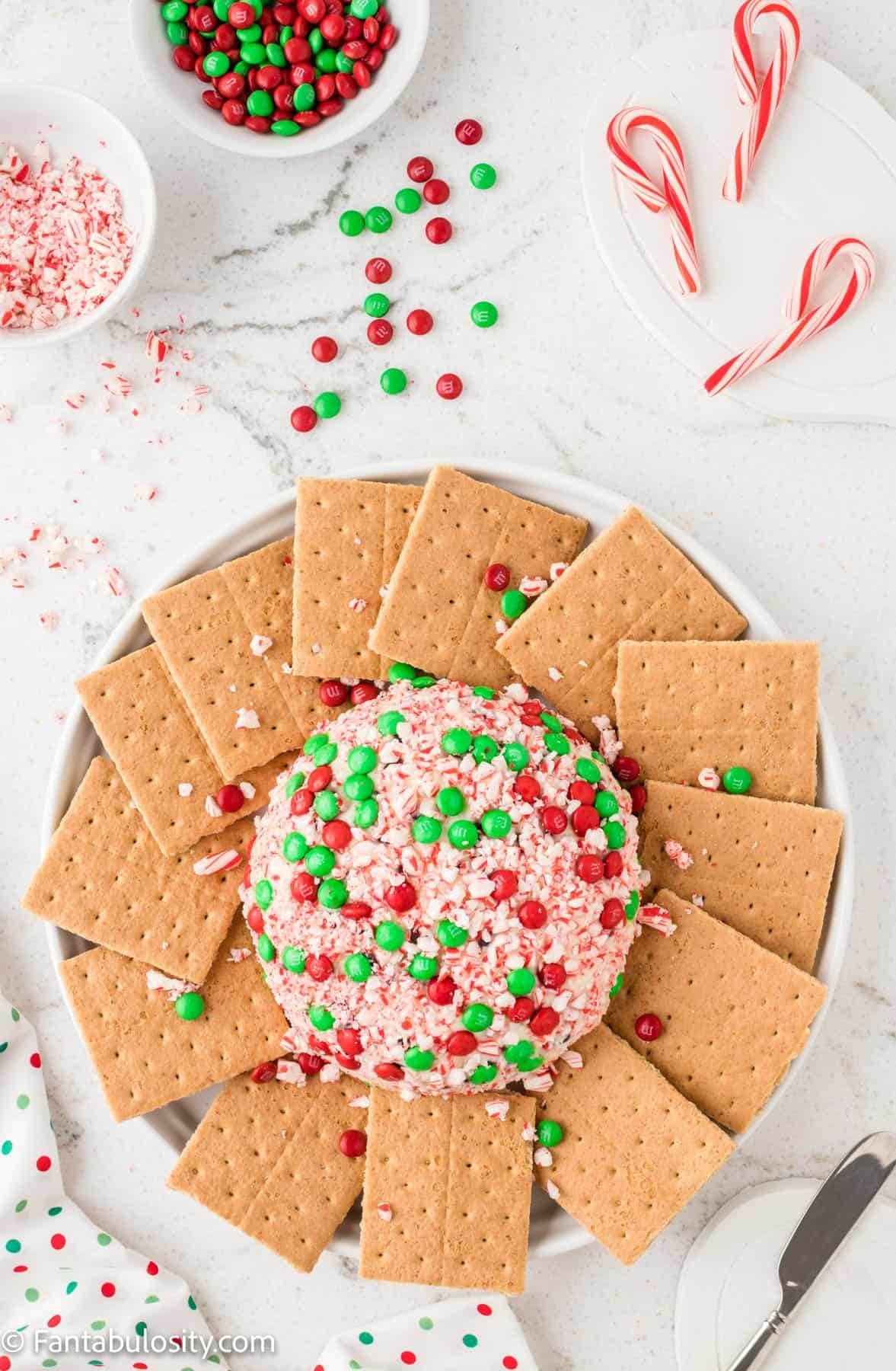 Cheeseball coated mini M&Ms and crushed candy canes served with crackers.