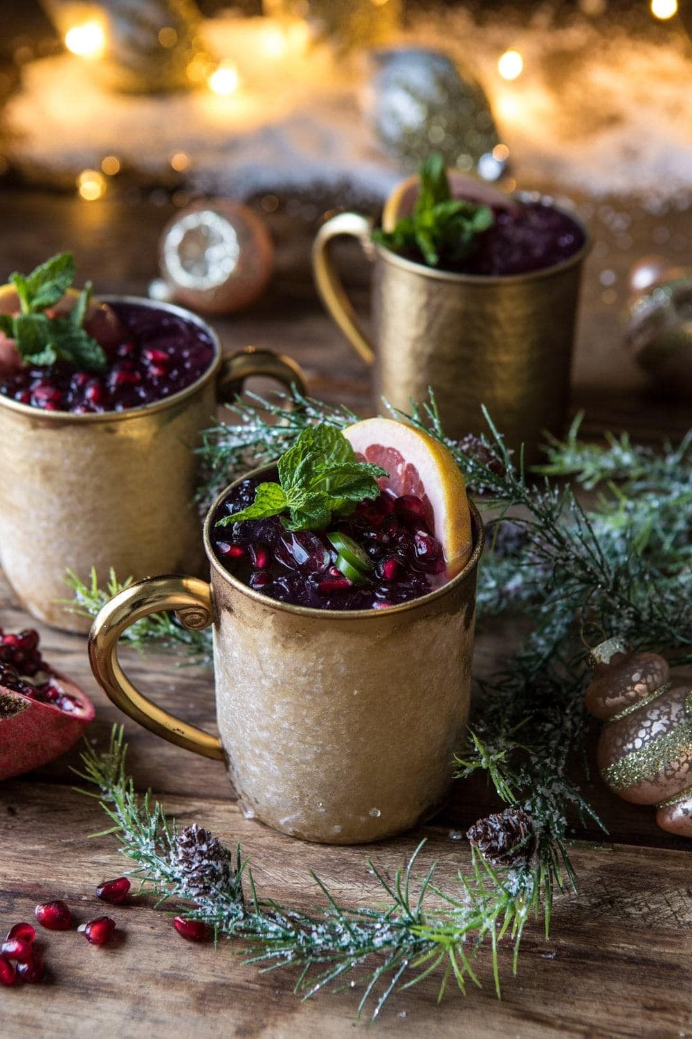 Moscow mules loaded with cranberries, ice and lemon slice.