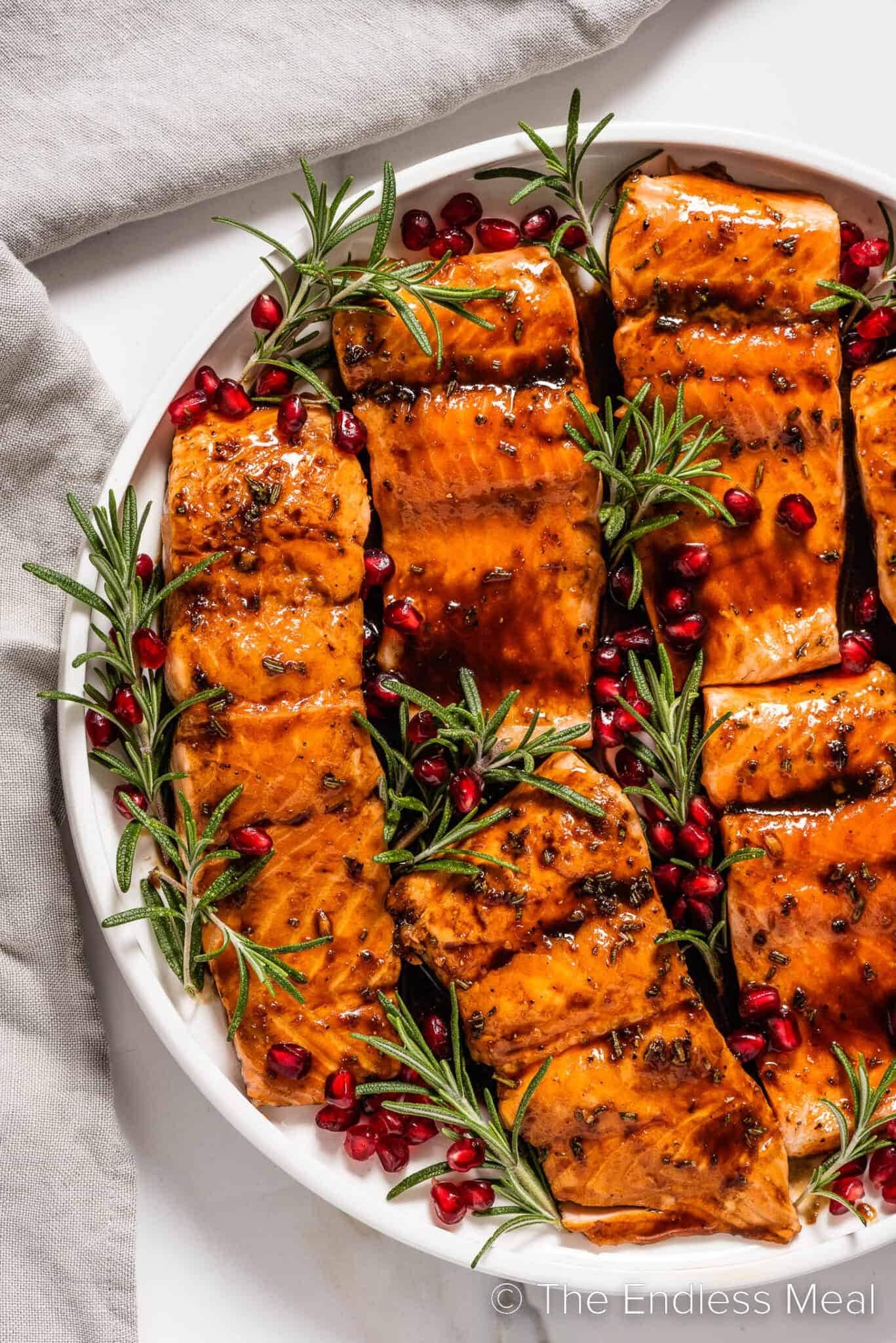 Glazed salmon with with fresh rosemary sprigs and pomegranate seeds.