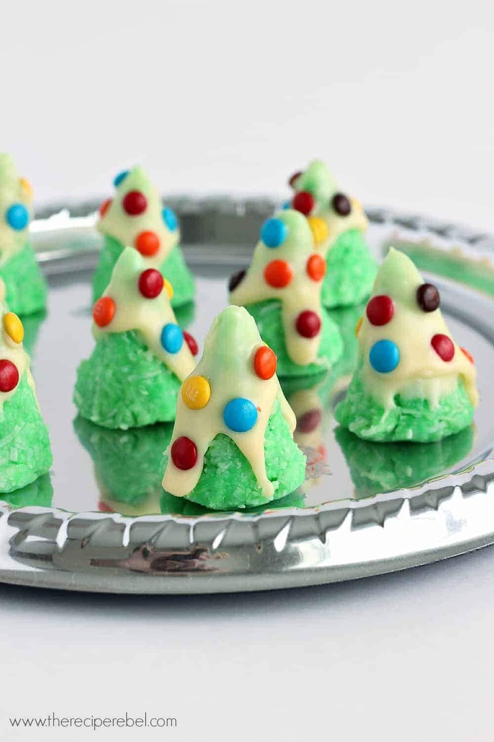 Green dough shaped in Christmas tree dipped on white chocolate decorated with M&M candies.