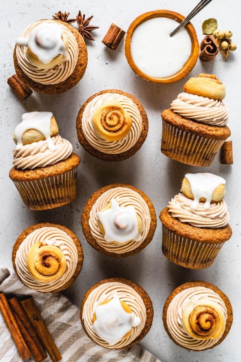Cinnamon cupcakes topped with frosting dusted with cinnamon powder.