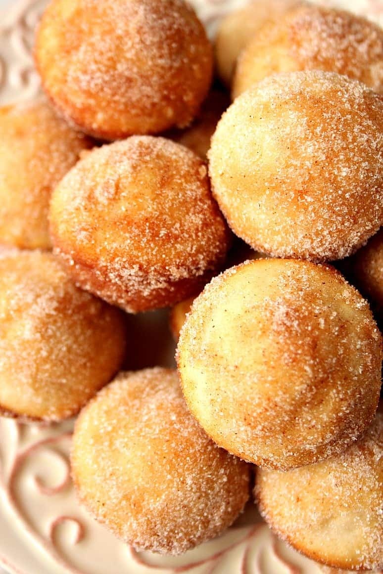 Bunch of mini donut muffins coated with sugar. 