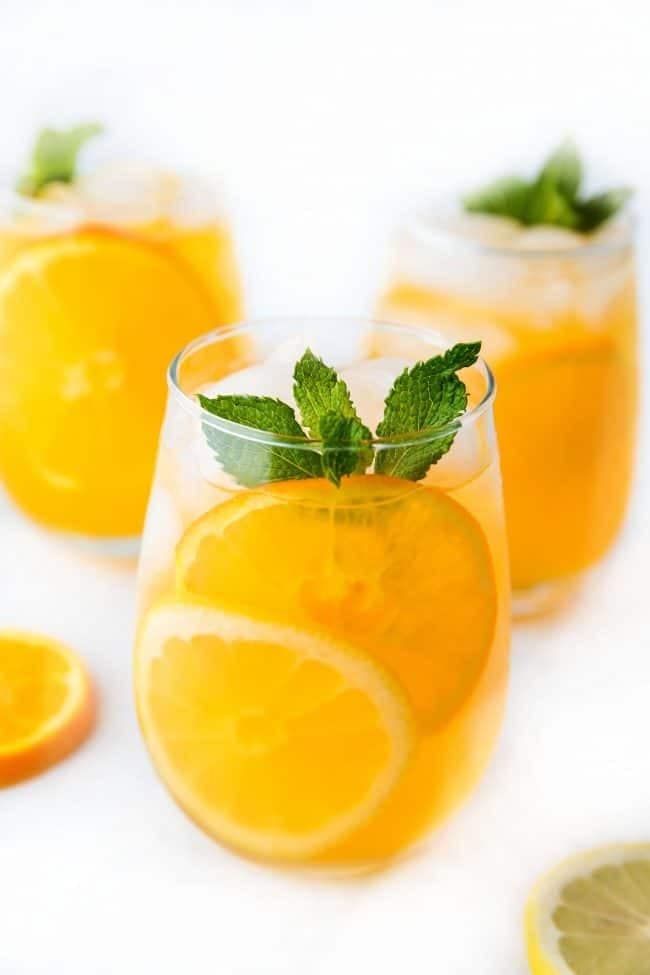 Orange and lemonade punch in glasses with mint leaves. 
