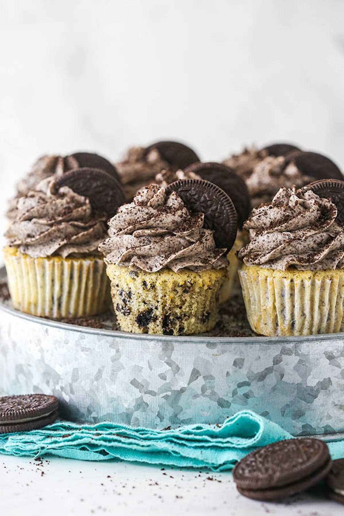 Cupcakes topped with cookies and cream frosting and a piece of cookie garnish. 