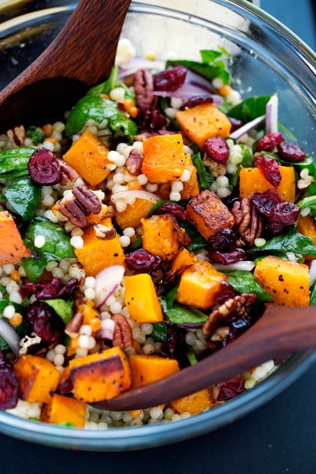 Autumn pearl couscous salad with roasted butternut squash on a clear glass bowl.