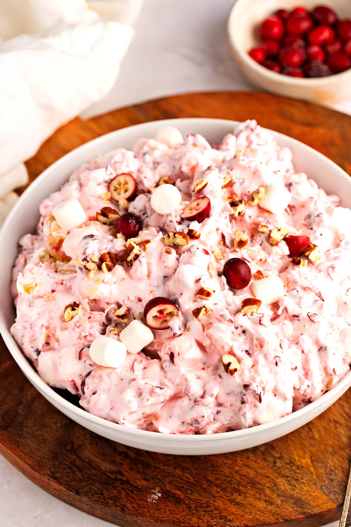 A bowl of cranberry fluff with marshmallows and nuts, a delightful mix of flavors and textures