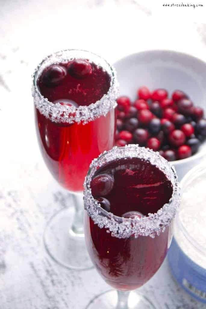 Two glasses of cranberry margarita with a bowl of cranberries.